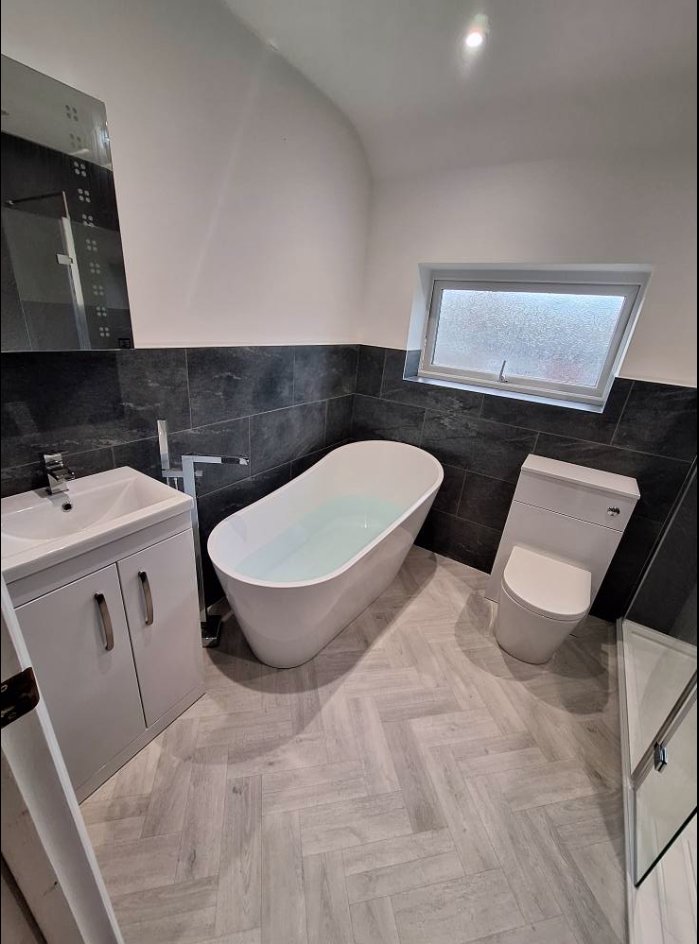 Dark Tile & Freestanding Bath by Bhatt Plumbing & Heating